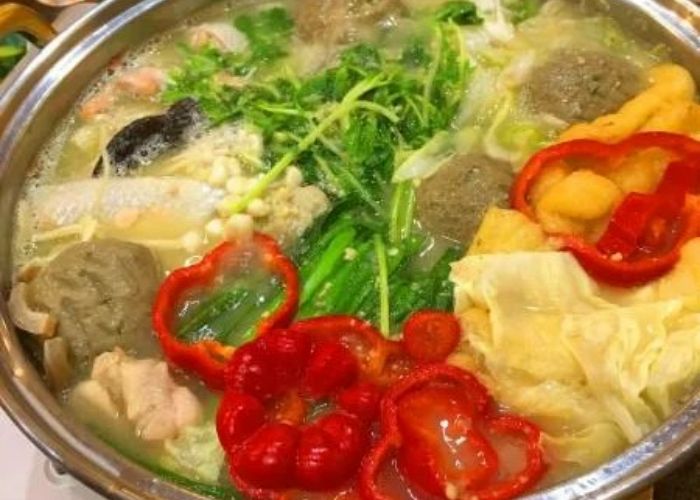 A nabe pot filled with broth, vegetables, and meats.